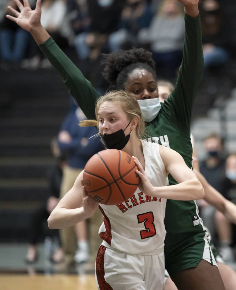 McHenry's Peyton Stinger looks to pass as Crystal Lake South's Kree Nunnally defends during their game on Tuesday, January 11, 2022 in McHenry.