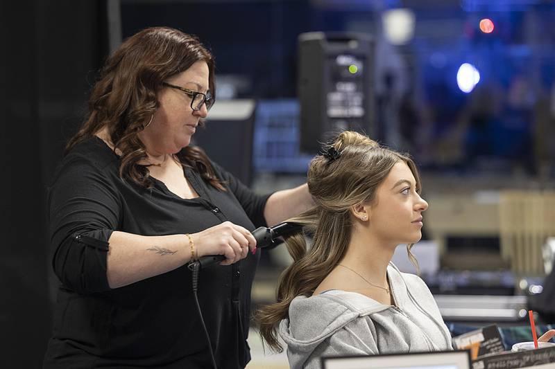 Merissa Hernandez of Karma Salon curls Brenleigh Cook’s hair Sunday, Feb. 2, 2025, at the Sauk Valley Wedding Expo held at the Northland Mall.