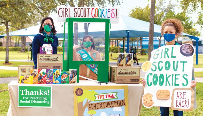 Girl Scouts selling their cookies at one of their booths.