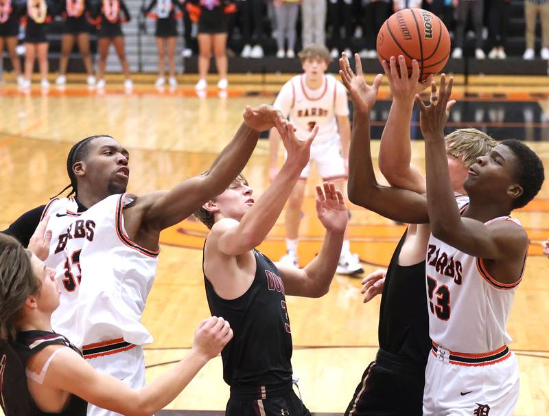 DeKalb's Chance Perry (left) and Davon Grant try to grab a rebound in a group of Dunlap players during their game Monday, Nov. 21, 2022, at DeKalb High School.
