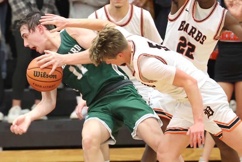 Glenbard West's Logan Brown is knocked down by DeKalb's Tyler Vilet during their game Tuesday, Nov. 29, 2022, at DeKalb High School.