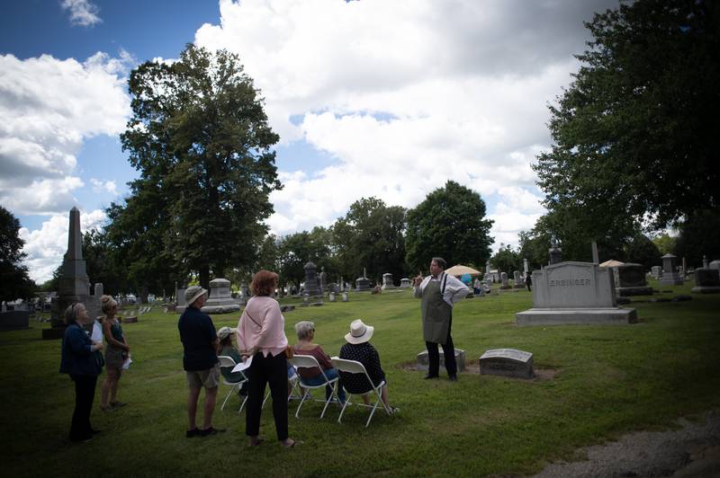 Joel Knapper, right, of Bourbonnais, portrays George Erzinger, a local grocer from the early 1900s at Mound Grove cemetery in Kankakee on Sunday, August 24, 2025.