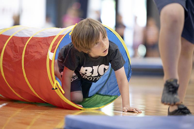 Tucker Gomes, 6, crawls through a tube during Dixon Park District’s The Kids Table fun camp Wednesday, May 31, 2023.