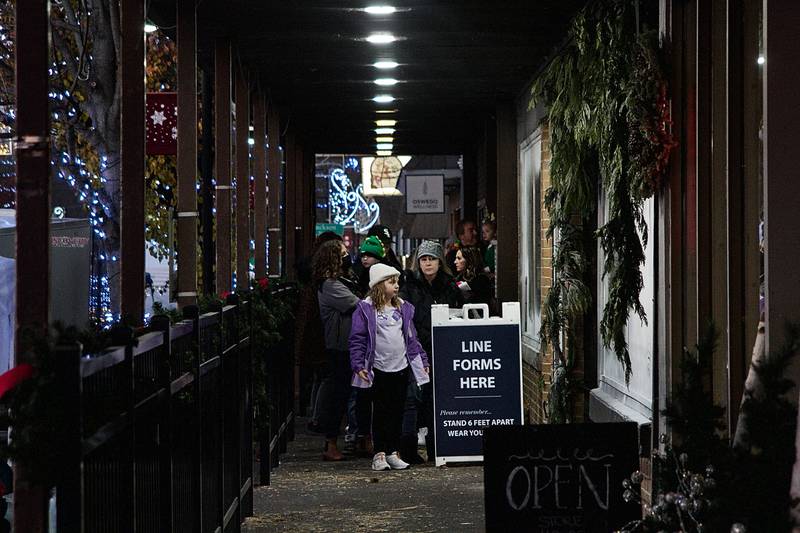 The line to have a socially-distant visit with Santa Claus at Locked In Photography stretched down the storefronts of Main Street in downtown Oswego on Dec. 3 as part of the annual Christmas Walk celebration.