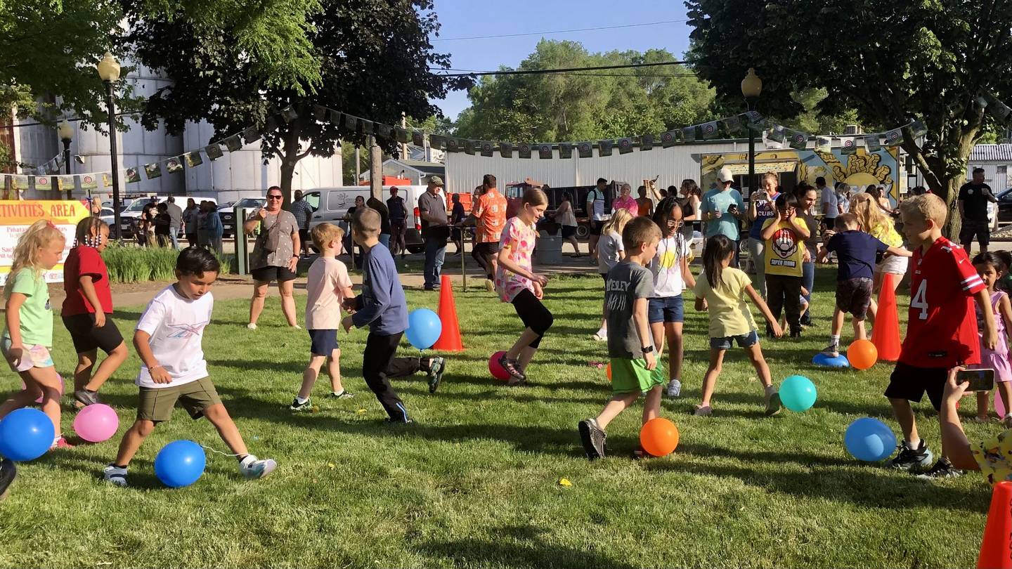 Children play Gallitos, or balloon pop game, at the Margaritas en Mayo event at Riverfront Park in Yorkville on May 23, 2024.