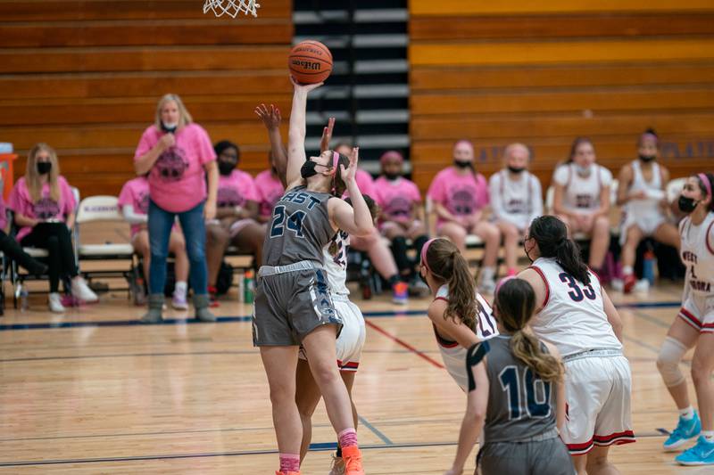 Oswego East's Ava Valek (24) goes up for a rebound against West Aurora during a basketball game at West Aurora High School on Wednesday, Jan 26, 2022.
