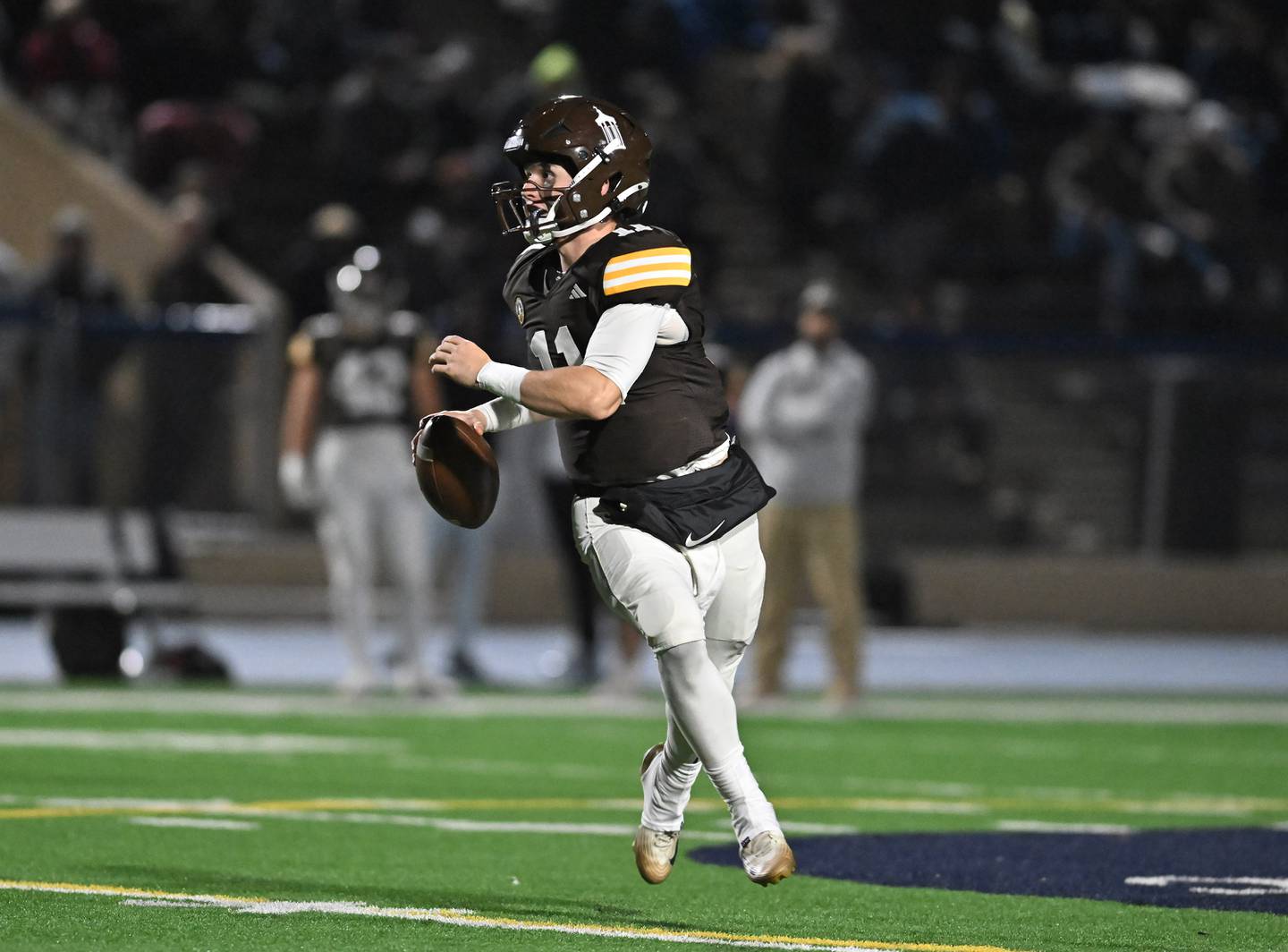 Joliet Catholic's Lucas Simulick (11) rolls out looking to throw a pass during the conference game against Providence Catholic on Friday, OCT. 24, 2025, at Joliet.