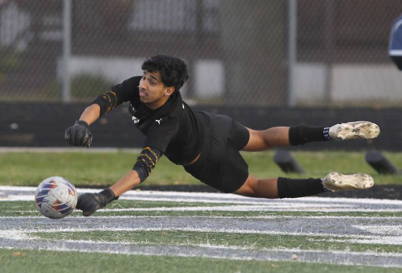 Harvard's Ricardo Flores makes a diving save during the IHSA Boys Soccer 2A Grayslake Central Sectional semifinal match against Wauconda on Tuesday, Oct. 29, 2024, at Grayslake Central High School,