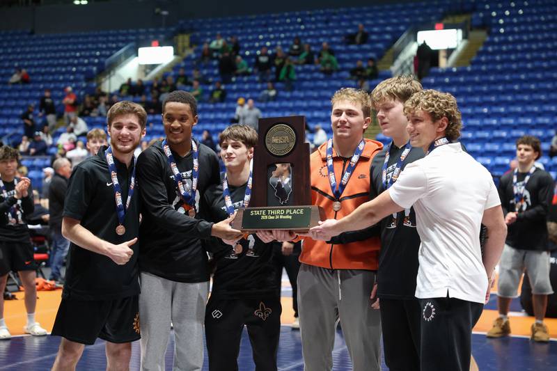 St. Charles East wrestlers pose with the IHSA Class 3A Dual Team State third place trophy following their victory over Oak Park-River Forest on Saturday, Feb. 28, 2026.