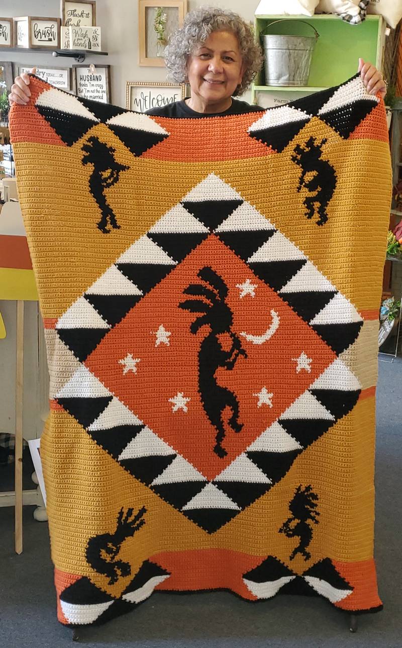 Artist Olga Torres with a Kokopelli graphgan she designed that will be raffled off.