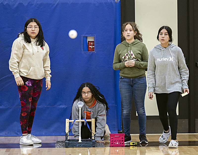 Seventh graders Sienna Thompson (left), watches as Ale Cid fires off their catapult Friday, Dec. 15, 2023 at Rock Falls Middle School. Arsenia Gragert (middle-left) and Maria Garcia were there to measure the throws.