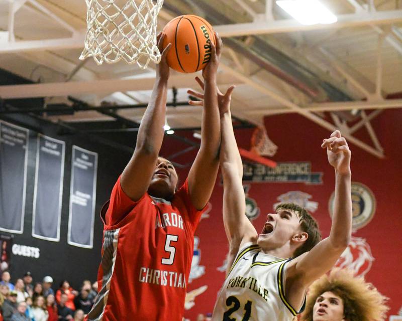 Yorkville Christian's Joradan Purvis (21) and Aurora Christian's Jordan Weeks (5) go up for a rebound during the regional title game on Friday Feb. 28, 2025, held at Indian Creek High School.