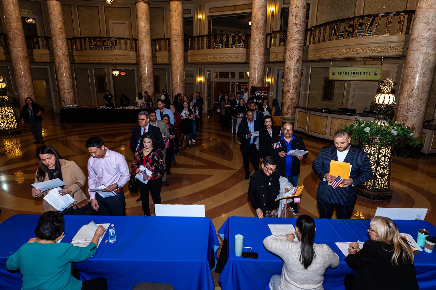 New U.S. citizens pick-up their official paperwork following the Naturalization Ceremony at Rialto Square Theatre in Joliet on April 17, 2025.