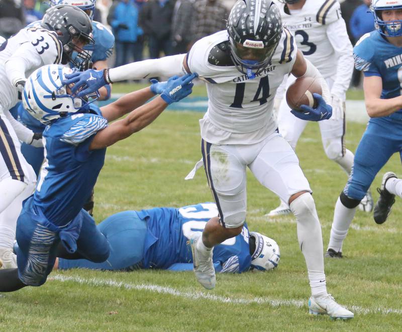 IC Catholic's KJ Parker stiff arms Princeton's Andrew Peacock (4) in the Class 3A Quarterfinal game on Saturday, Nov. 12, 2022 in Princeton.