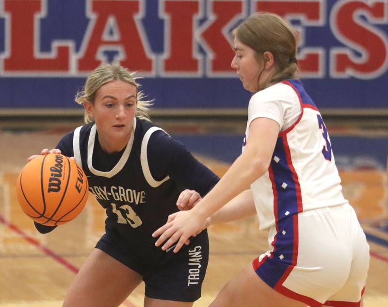 Cary-Grove’s Malaina Kurth, left, moves the ball as Lakes’ Wrenna Streicher defends  in varsity girls basketball action on Friday, Jan. 2, 2026  at Lakes High School in Lake Villa.