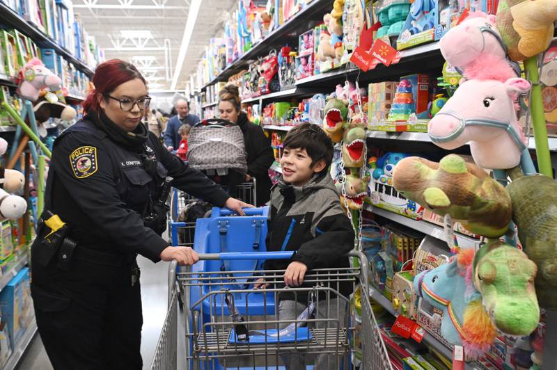 Andel Lopez, 9, of Carpentersville shops with Carpentersville Police Officer Kate Compton during the Dundee Township Shop with a Cop event at Walmart on Saturday, Dec. 14, 2024 in Carpentersville.