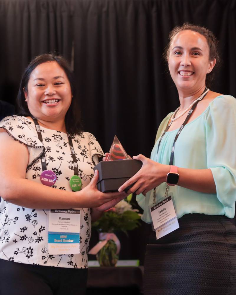 Felicia Camacho, right, Recreation Supervisor of Historical Programming at the Downers Grove Park District, accepts the Best Practices Award from the Association of Midwest Museums.