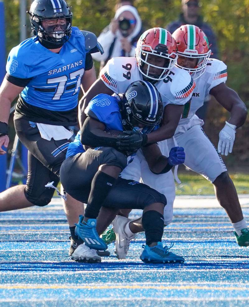 Morgan Park's Dion Andrews (99) hits St. Francis' Tyvonn Ransom (8) in the backfield for a loss during a class 5A state quarterfinal football game at St. Francis High School in Wheaton on Saturday, Nov 11, 2023.