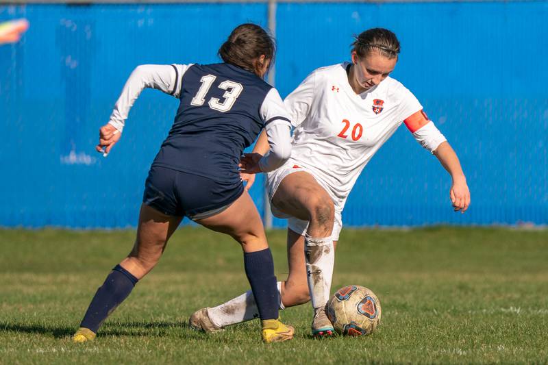 Oswego’s Anna Johnson (20) plays the ball against Oswego East's Jocelyn Cruz (13) during a soccer match at Oswego East High School on Thursday, Apr 6, 2023.