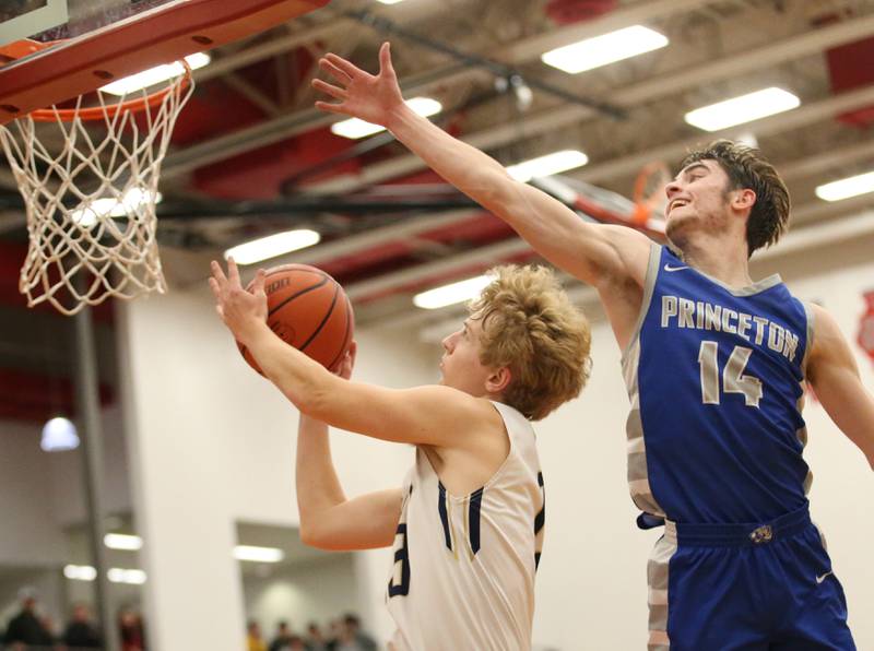 Marquette's Griffin Walker (left) cuts inside Princeton's Grady Thompson (right) to score a basket during the Colmone Classic tournament on Friday, Dec. 9, 2022 at Hall High School in Spring Valley.