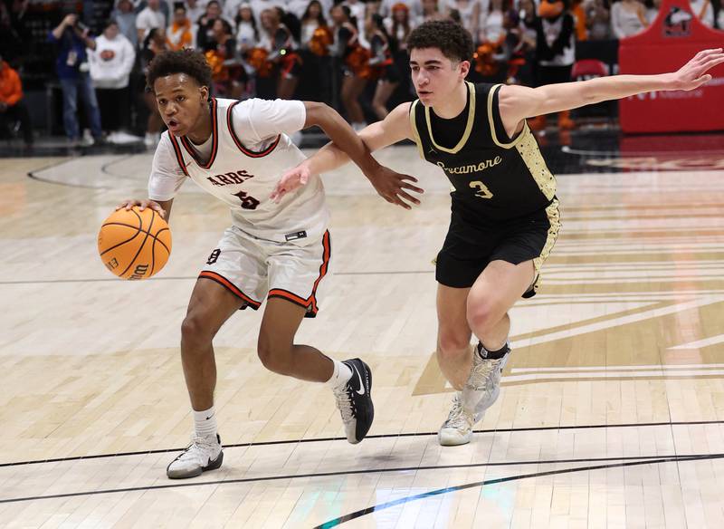 DeKalb's Bryan Miller drives by Sycamore's Marcus Johnson Friday, Jan. 30, 2026, during the FNBO Challenge at the Convocation Center at Northern Illinois University in DeKalb.