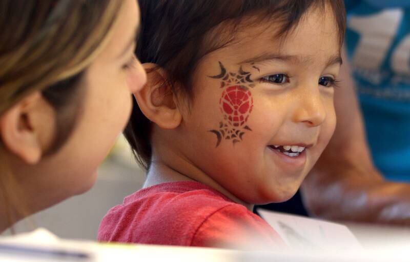 Alex Bartilotta, 3, of Huntley grins after making a stamp featuring the monarch lifecycle during Monarchs and Music at Crystal Lake Main Beach Sunday.