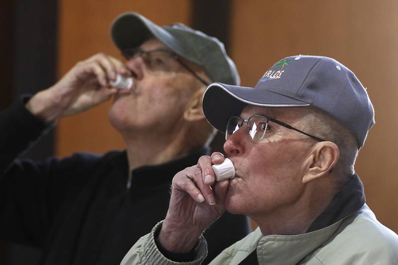 Dale Hatter, of Huntley, and Richard Kilian, of Roselle, drink maple syrup during a maple syrup tasting during the McHenry County Conservation District’s annual Festival of the Sugar Maples, at Coral Woods Conservation Area, in Marengo, on Monday, March 11, 2024.I like the symmetry of the two men as they drink maple syrup.