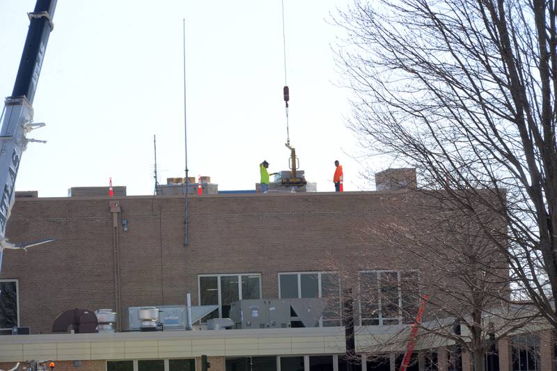 Workers unload solar panel materials on the roof of Polo Community High School on Saturday, March 2, 2024.