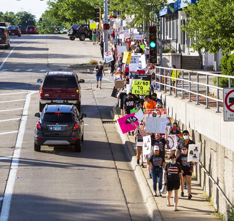 Cars wait in a turn lane as a Black Lives Matter march passes by along First Avenue in Sterling. The march, organized by the YWCA of the Sauk Valley, included a few hundred protester who walked with signs from Sterling to Rock Falls and back. While in Rock Falls, protesters listened to speakers at the RB&W District Riverfront Park.