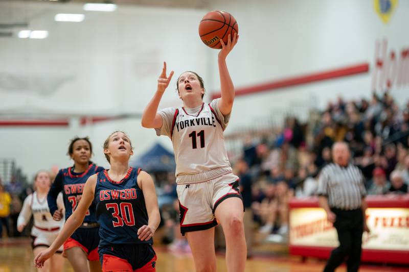 Yorkville's Brooke Spychalksi (11) drives to the basket against Oswego during the 13th annual Hoops 4 Hope Communities vs. Cancer basketball event at Yorkville High School on Saturday, Jan 28, 2023.