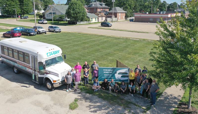 Volunteers and community members pose for a photo where the future home of the Second Story Teen Center will be built at the intersection of Crown Street and South Main Street on Wednesday, Aug. 16, 2023 in Princeton.