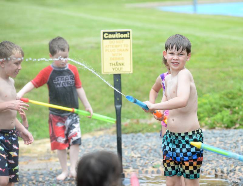 Jacoby Morehead, 9 of Oregon, sprays water at some of his buddies while at the Oregon Park District's Splash Pad at Oregon Park West on Tuesday, June 4, 2024. The park district hosted a pop-up and play event during the afternoon complete with a bubble machine and various types of water guns. The Splash Pad is located next to the shelter and playground at Park West.