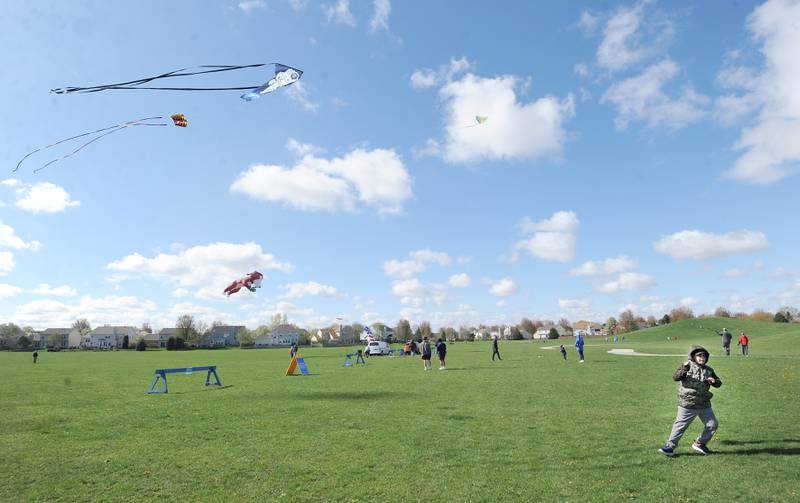 Nine-year-old Eddie Diaz of Aurora pulls his kite higher during a celebration of Earth Day and National Kite Month at Prairie Point Park in Oswego, Saturday, April 20, 2024.