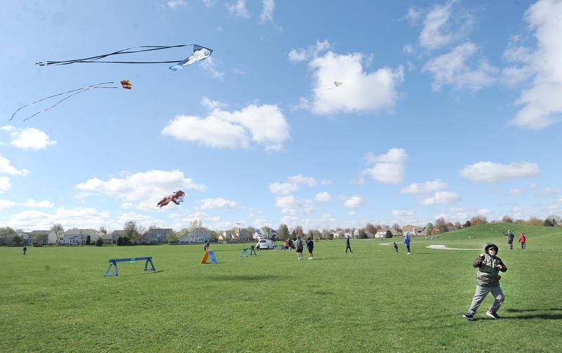 Nine-year-old Eddie Diaz of Aurora pulls his kite higher during a celebration of Earth Day and National Kite Month at Prairie Point Park in Oswego, Saturday, April 20, 2024.