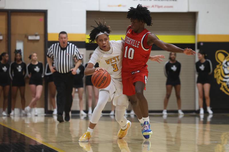 Joliet West’s Tristian Saunders forces his way around Yorkville’s Kaevian Johnson on Friday, Jan. 5th, 2024. in Joliet.