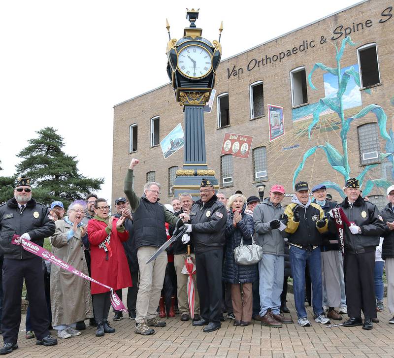 The crowd cheers and Rotary President Brian Corr gives a shout after he and Manny Olade, Commander of DeKalb American Legion Post 66, cut the ribbon on the newly renovated Soldiers' and Sailors' Memorial Clock Thursday, Nov. 11, 2021, during a Veterans Day ceremony at Memorial Park in downtown DeKalb.