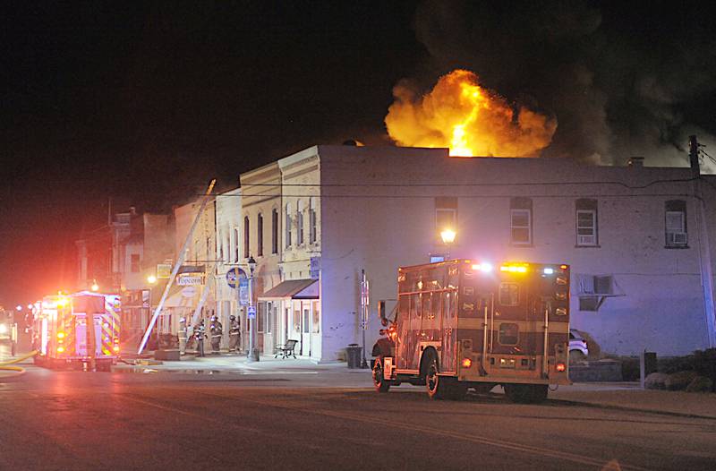 Smoke and flames emerge from an apartment outside Skoogs Pub & Grill on Sunday, May 10, 2015 downtown Utica.