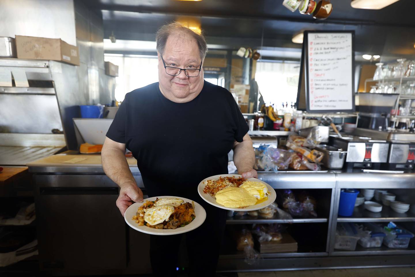 Scott Beltran, owner of Daddio's Diner in Batavia holds two plates of eggs ready to go out to diners Thursday, Feb. 13, 2025.