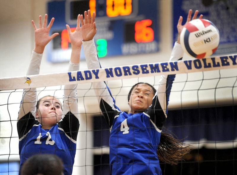 Along with Newark teammate Madison Sittler (12), Kiara Wesseh (4) blocks an Aurora Christian shot for a score during a girls' volleyball match at Newark High School on Tuesday, Sep. 5, 2023.