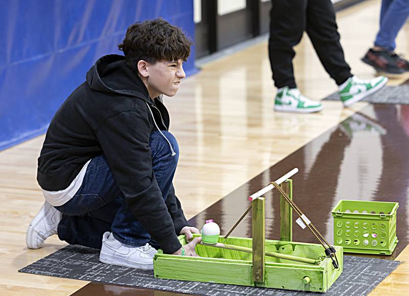 Juelious Olivas, an eighth grader at Rock Falls Middle School, eyes the target Friday, Dec. 15, 2023 during the school’s STEAM catapult competition. Olivas and teammate Lilly Evanson won the three grade competition with a throw of 72 feet.