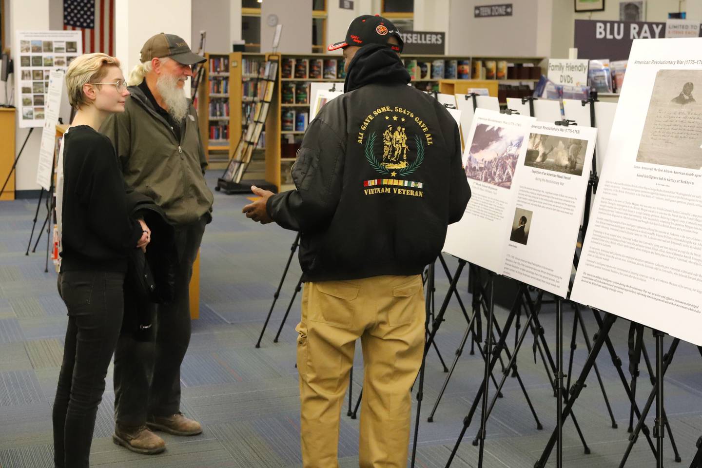DeKalb resident Daniel "Doc" Habeel (right) speaks with patrons at the Sycamore Public Library in November 2024. Patrons came to view Habeel's "A Picture Exhibit of African American Patriots," a traveling photo exhibit he curated to share Black military history. The exhibit will begin traveling again in February 2025 in time for Black History Month.