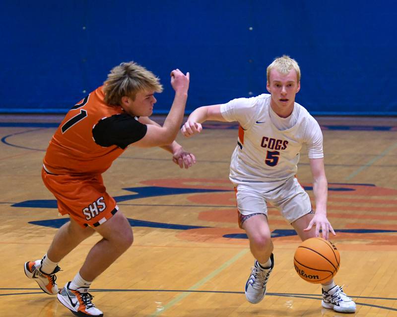 Genoa-Kingston's Blake Ides (5) tries to get around Sandwich's Noah Campbell (21) while looking for his next move during the game on Thursday Dec. 12, 2024, held at Genoa-Kingston High School.