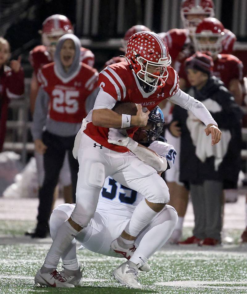 Naperville Central's Christopher Bern is wrapped up by Downers Grove South's Rj Samuels (35) Friday October 27, 2023 in Naperville.