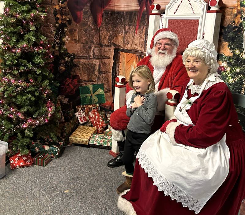 Evie Cooper, 4, of Byron, smiles as she visits with Santa and Mrs. Claus at the Conover Square Mall during Oregon's Candlelight Walk on Saturday, Dec. 6, 2025.