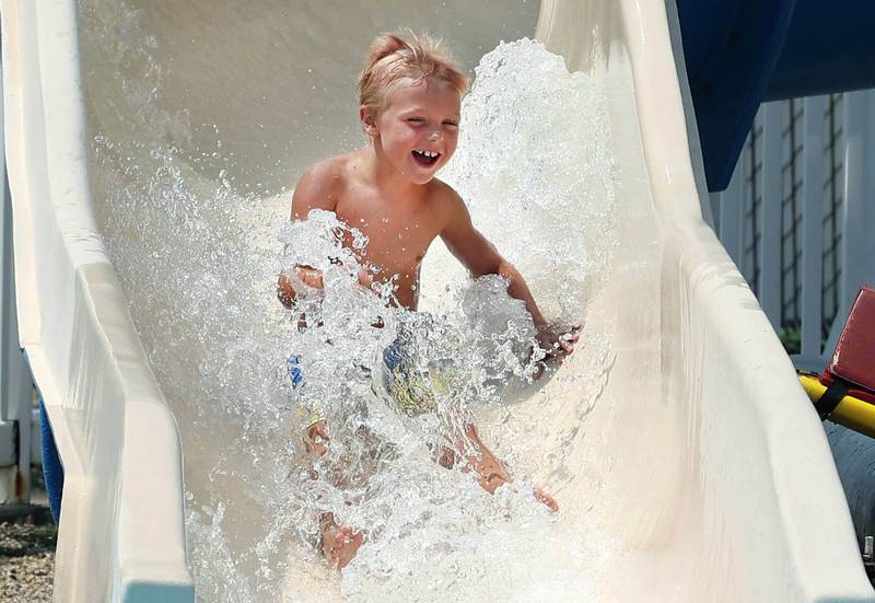 Corbin Campbell, 7, from DeKalb, slides down one of the water slides Tuesday, July 25, 2023, at Hopkins Pool in DeKalb.