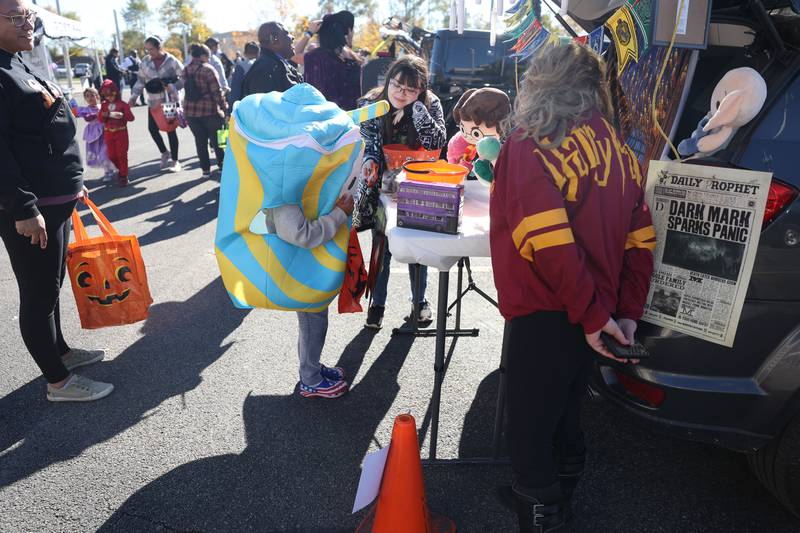 A kid gets candy at the Harry Potter decorated vehicle at the Joliet Police Department Trunk-Or-Treat event on Saturday, Oct. 26, 2024 in Joliet.