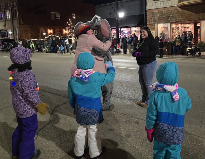 A woman hugs an elephant character Saturday, Nov. 30, 2024, during the Lighted Christmas Parade in Streator. The character was played by a Streator High School Key Club member.