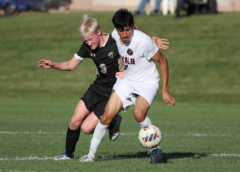 DeKalb's Jorge Correa tries to hold off Sycamore's Paxton Nicol during the El Classicorn rivalry game Tuesday, Oct. 7, 2025, at Sycamore High School.
