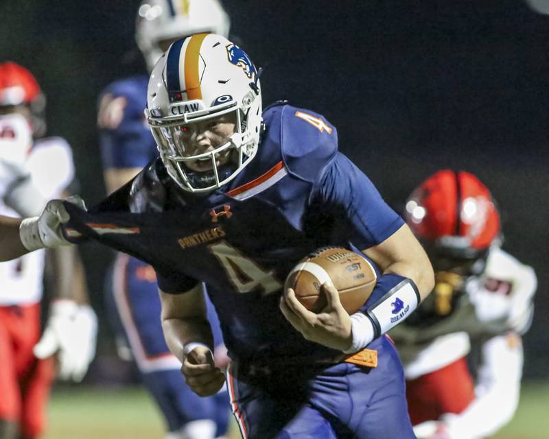 Oswego's Drew Kleinhans (4) scrambles away from the defense during football game between Bolingbrook at Oswego Friday, Sept 12, 2025  in Oswego.