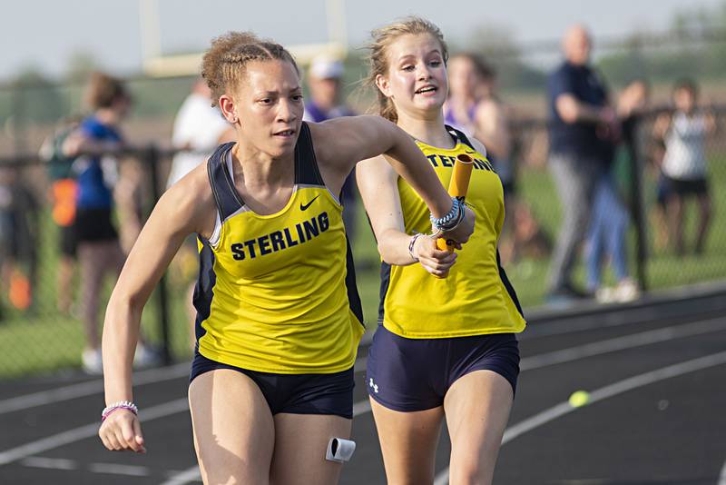 Sterling's Kirra Gibson takes the baton from teammate Anna Aulwes in the 4x100 at the 2A track sectionals in Geneseo on Wednesday, May 11, 2022.